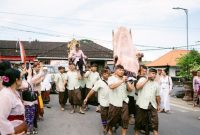 Prosesi Ngaben di Bali dengan bade megah yang diarak, menunjukkan kemeriahan dan spiritualitas yang mendalam dalam mengantar arwah menuju alam keabadian. Gambar ini merekam salah satu momen paling sakral dan fotogenik dari tradisi pemakaman unik di Indonesia.
