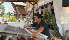 Suasana Desa Tenganan Pegringsingan yang khas dengan tata letak rumah tradisionalnya, mencerminkan kehidupan masyarakat Bali Aga yang teguh menjaga warisan leluhur mereka. Para perempuan Bali Aga tampak tengah menenun kain gringsing, sebuah warisan budaya tak ternilai yang membutuhkan kesabaran dan keahlian tinggi.