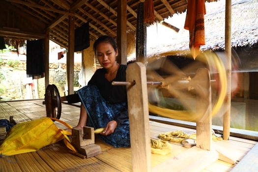 Pemandangan rumah-rumah tradisional dengan tembok batu tinggi di Desa Tenganan Pegringsingan, menunjukkan arsitektur unik yang dijaga ketat oleh masyarakat Bali Aga. Seorang wanita Bali Aga sedang menenun kain gringsing menggunakan teknik double ikat, sebuah warisan budaya tak ternilai yang membutuhkan kesabaran dan keahlian tinggi.